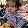 Maraya is registered to the contest to win money with this photo: toddler, child, curly_hair, striped_shirt, yellow_pants, indoor, blankets, cozy, big_eyes, pout, cute, sitting, colorful, soft_lighting, earrings, toy, bedroom, portrait, person, young_child