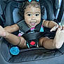 Maraya is registered to the contest to win money with this photo: baby, car_seat, child, smiling, blue_bow, black_hair, happy, seatbelt, infant, kicking, cute, close_up, indoors, pacifier, clothing, safety, person, face, legs, playful