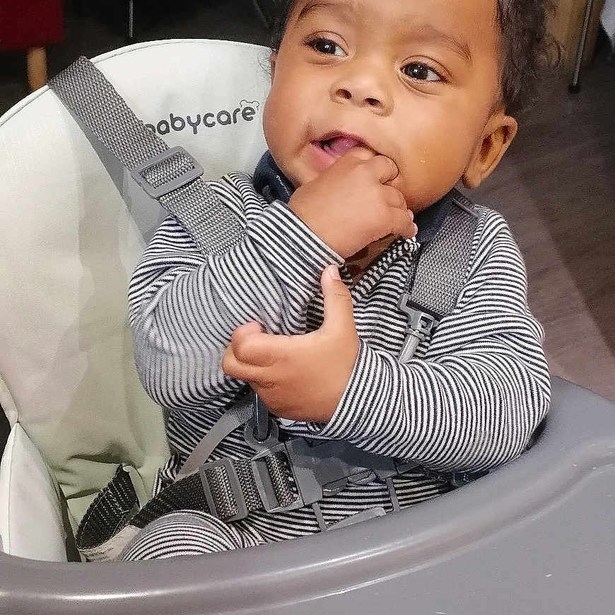 Wilden a rejoint le concours — aidez-le/la à gagner de superbes lots ! baby, babycare_brand, casual, child, clothing, curly_hair, expression, face, fingers_in_mouth, floor, furniture, high_chair, home, indoors, person, seatbelt, striped_clothing, teething, tray_table, young_child