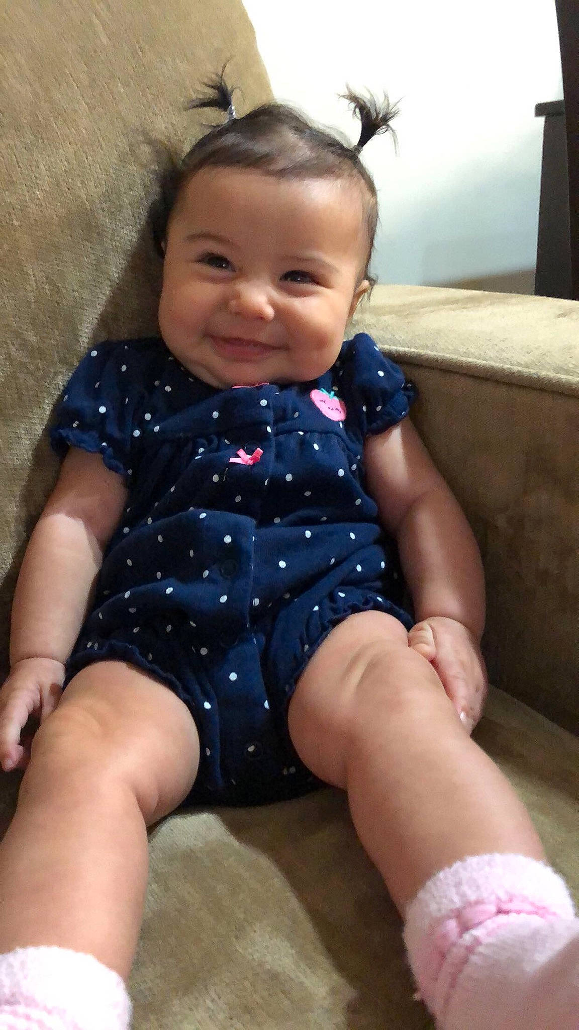 Giana is registered to the contest to win money with this photo: baby, baby_toddler_clothing, cheek, child, eye, face, finger, foot, iris, joy, lap, mouth, nail, nose, overall, person, sitting, skin, sock, thigh