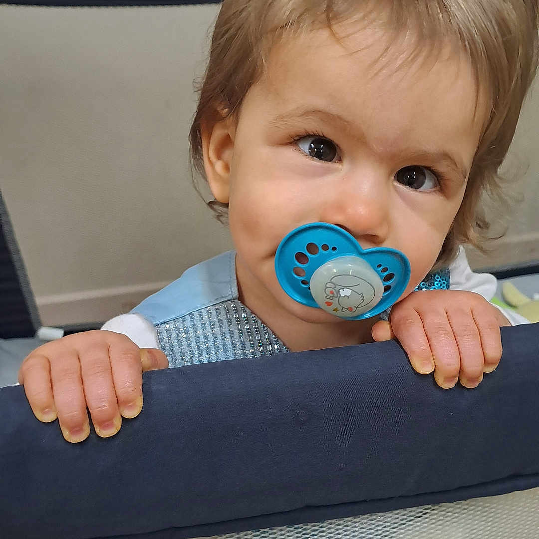 Valentyna a rejoint le concours — aidez-le/la à gagner de superbes lots ! baby, blue, child, clothing, curious, cute, expression, eyes, face, grip, hair, hands, indoor, infant, pacifier, person, playpen, portrait, toddler, young