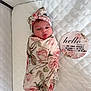 baby, birth_announcement, blanket, card, child, cute, face, floral, headband, infant, lying_down, newborn, person, portrait, quilt, sleeping_area, soft, swaddled, tongue, white