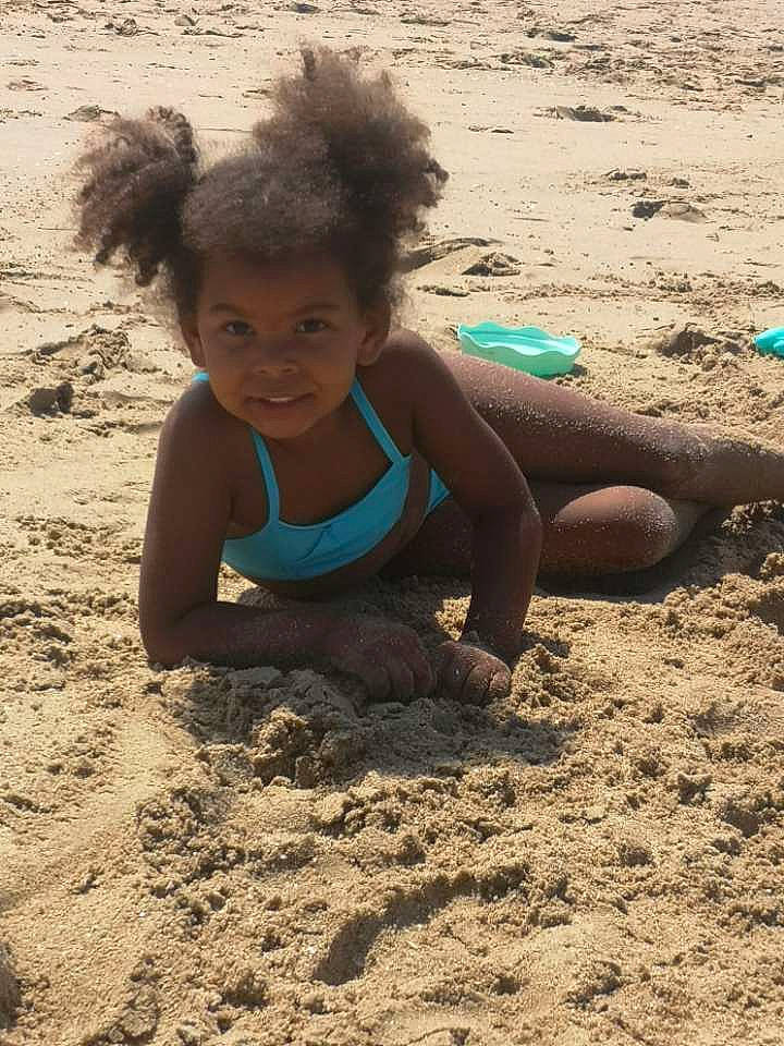 Haimy a rejoint le concours — aidez-le/la à gagner de superbes lots ! beach, child, fun, grass, happy, human_leg, landscape, leisure, mud, people_in_nature, people_on_beach, person, play, shadow, sitting, smile, soil, swimwear, t_shirt, thigh