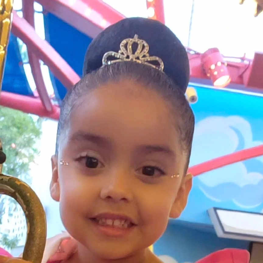 Mia is registered to the contest to win money with this photo: accessories, amusementpark, baby, bodypart, crown, earring, face, happy, head, jewelry, mouth, necklace, outdoors, person, photography, playarea, portrait, smile, sunglasses, tiara