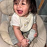Aarón joined the competition — help win amazing prizes! baby, child, smiling, happy, indoor, baby_chair, clothing, sock, cute, portrait, person, infant, toddler, white_shirt, gray_pants, furniture, face, hand, foot, playful