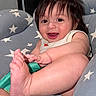 baby, child, smiling, happy, foot, hand, hair, face, cushion, seat, stars, clothing, indoor, skin, infant, cute, portrait, baby_toy, playful, relaxed