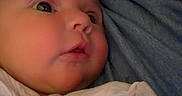 Eleanor joined the competition — help win amazing prizes! baby, infant, child, face, portrait, wide_eyed, indoors, swaddled, blanket, cuddling, adult, parent, gray_shirt, cozy, close_up, lying_down, soft_lighting, home, photography, cute