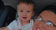Serenity joined the competition — help win amazing prizes! child, toddler, adult, glasses, smile, car_interior, seat, clothing, person, holding, happy, face, portrait, arm, hair, young_adult, casual_wear, light, indoor, together