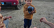 Elias joined the competition — help win amazing prizes! child, boy, chicken, bird, outdoor, gravel, yard, pickup_truck, vehicle, red_truck, rural, house, trees, bare_trees, sunset, standing, holding, animal, family, portrait