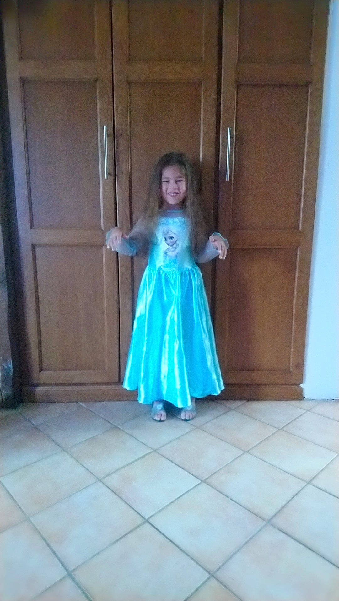 Jaya a rejoint le concours — aidez-le/la à gagner de superbes lots ! aqua, blue, child, clothing, costume, dress, electric_blue, floor, flooring, formal_wear, fun, gown, haute_couture, joy, long_hair, person, shoulder, smile, standing, toddler