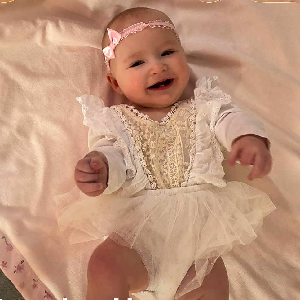 Annabelle is registered to the contest to win money with this photo: baby, infant, smiling, lace, tulle, headband, pink, blanket, cute, happy, child, clothing, portrait, laying_down, hands, face, cheerful, indoors, soft_texture, young