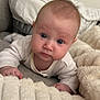 Navy is registered to the contest to win money with this photo: baby, infant, face, blue_eyes, blanket, couch, soft_texture, curious, indoor, closeup, person, child, clothing, sleeve, head, skin, expression, furniture, cozy, resting