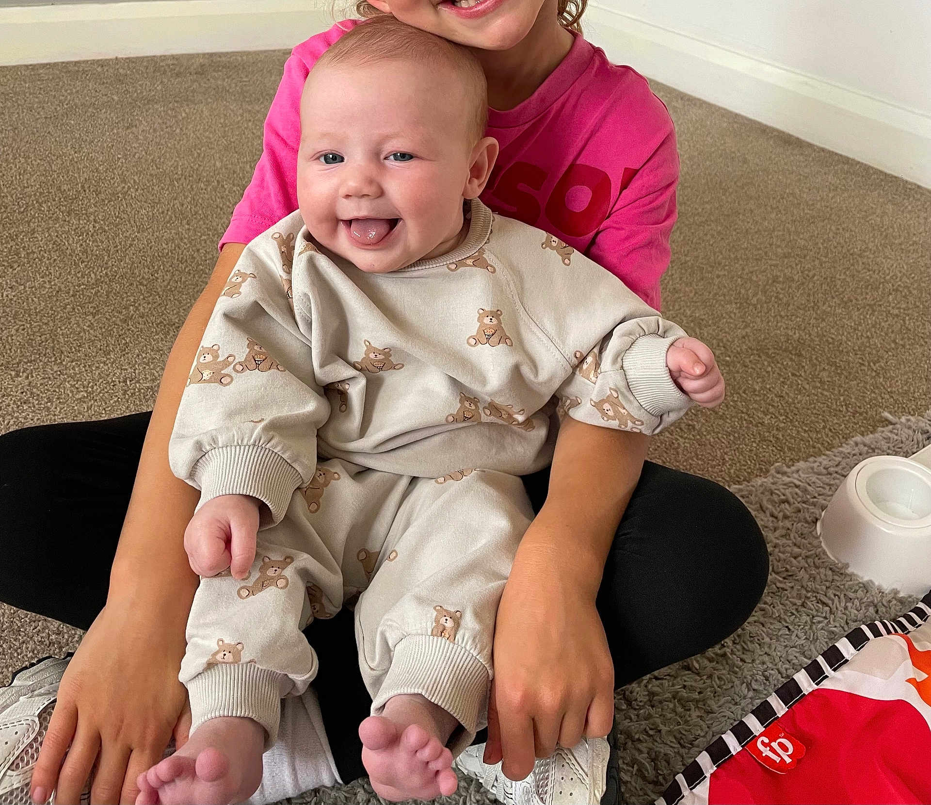 Navy joined the competition — help win amazing prizes! baby, child, smile, tongue_out, pajamas, bear_print, pink_shirt, carpet, indoor, play_mat, toy, sibling, happy, hands, feet, person, seated, cute, holding, casual_clothing