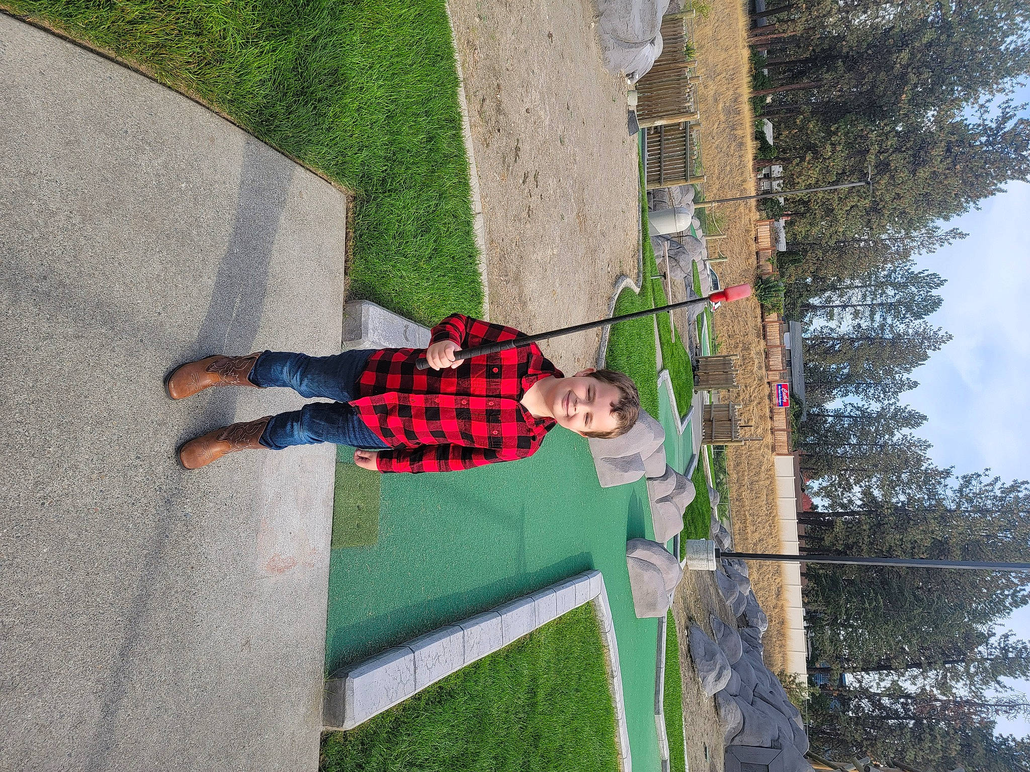 Travis is registered to the contest to win money with this photo: asphalt, concrete, flooring, grass, joy, leisure, pattern, people_in_nature, person, plant, play, recreation, road_surface, shadow, shrub, sidewalk, sky, toddler, tree, walking_shoe