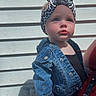 toddler, child, denim_jacket, headband, leopard_print, outdoor, person, portrait, holding, hand, face, blue_eyes, shadow, sunlight, wall, horizontal_lines, casual, clothing, baby, expression