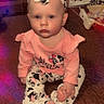 baby, infant, child, sitting, pink_clothing, headband, cow_pattern, footwear, indoor, carpet, furniture, dresser, toy, earrings, cute, portrait, expressionless, floor, lighting_effects, baby_girl