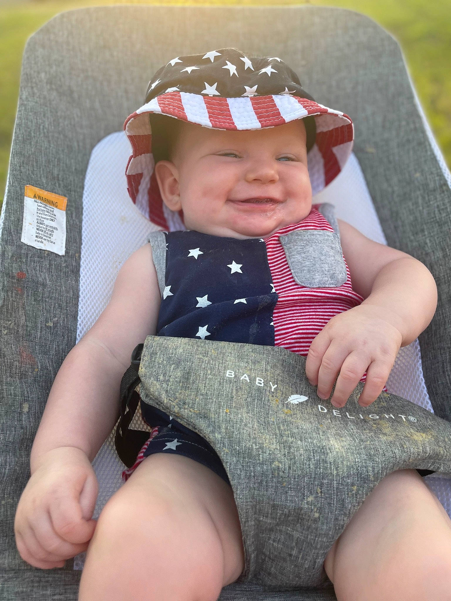 Atticus joined the competition — help win amazing prizes! baby, baby_toddler_clothing, child, comfort, eye, finger, fun, grass, happy, head, headgear, headwear, human_body, human_leg, knee, lap, person, skin, smile, sun_hat