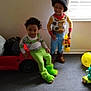 carpet, child, costume, cowboy_hat, curly_hair, curtain, dress_up, footwear, fun, green_slippers, happy, indoor, kids, playing, room, smiling, toy, toy_car, window, yellow_balloon