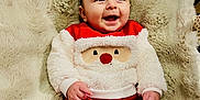 Léandre participe au concours pour gagner de l'argent avec cette photo : baby, infant, smile, red_clothing, white_clothing, santa_design, blanket, fur_blanket, happy, cute, child, indoor, portrait, person, cozy, holiday, christmas, festive, hands, face