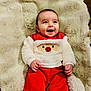 baby, infant, smile, red_clothing, white_clothing, santa_design, blanket, fur_blanket, happy, cute, child, indoor, portrait, person, cozy, holiday, christmas, festive, hands, face