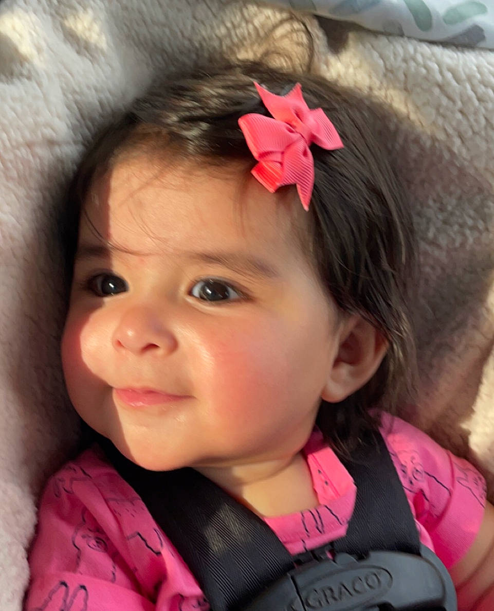 Marianna is registered to the contest to win money with this photo: baby, cheek, chin, cool, ear, eyebrow, eyelash, facial_expression, flower, hair, happy, head, iris, lip, neck, nose, person, pink, skin, sleeve