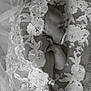 baby, infant, pacifier, lace, floral_pattern, black_and_white, newborn, sleeping, delicate, textile, fabric, portrait, closeup, soft, peaceful, hand, face, skin, blanket, resting