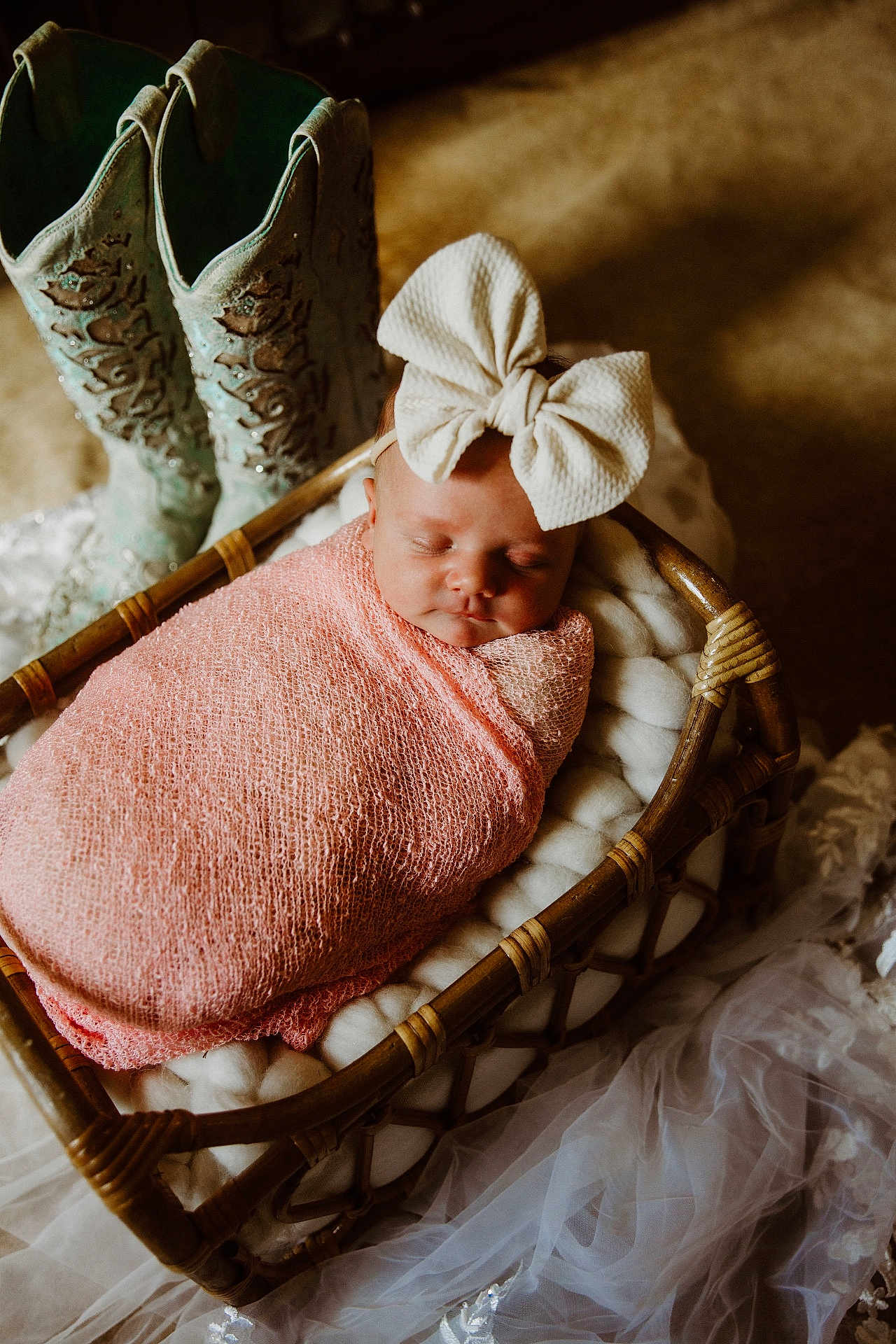 Piper is registered to the contest to win money with this photo: baby, sleeping, bow, headband, pink_wrap, wicker_basket, cushion, cowboy_boots, turquoise_boots, fabric, soft_texture, cozy, indoor, portrait, newborn, infant, rest, cute, child, peaceful