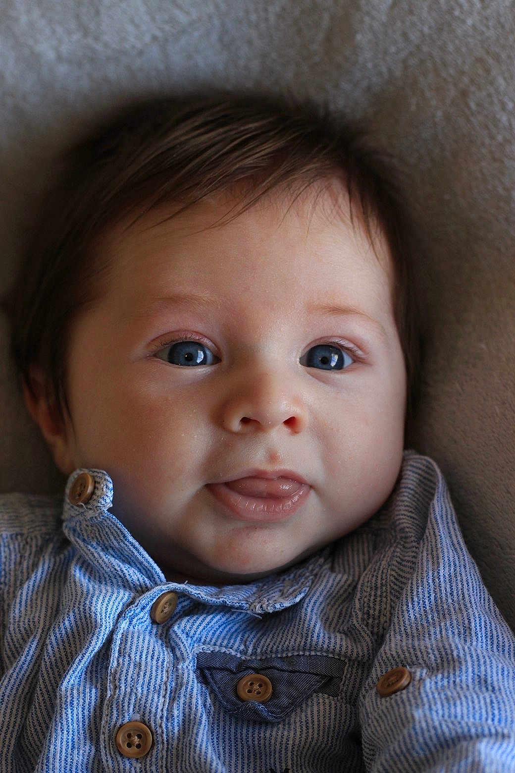 Paolo a rejoint le concours — aidez-le/la à gagner de superbes lots ! baby, infant, blue_eyes, tongue, striped_shirt, buttoned_shirt, closeup, face, cute, portrait, child, young, soft_background, lying_down, adorable, skin, head, expression, clothing, button