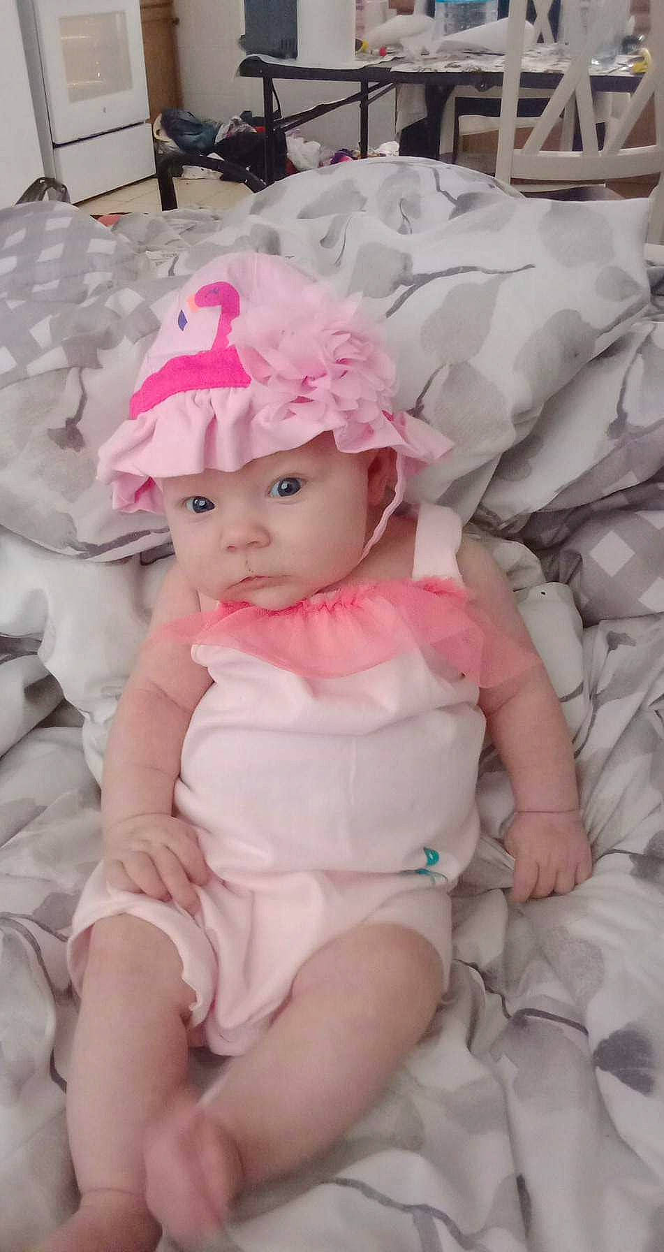Lilli'Annah is registered to the contest to win money with this photo: baby, baby_toddler_clothing, child, comfort, dress, embellishment, face, fashion_accessory, hair_accessory, headband, headpiece, headwear, lip, pattern, person, petal, pink, purple, sitting, skin