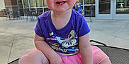 Maci is registered to the contest to win money with this photo: toddler, child, smiling, pink_bow, purple_shirt, butterfly, outdoor, table, barefoot, happy, person, daylight, casual, building, window, concrete, seat, playful, cute, baby