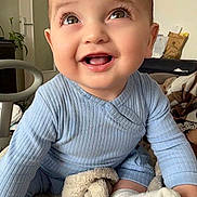 Elyas participe au concours pour gagner de l'argent avec cette photo : baby, smiling, blue_outfit, blanket, indoor, happy, child, cute, face, eyes, hand, sock, furniture, plant, door, living_room, soft_texture, cozy, portrait, infant