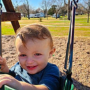 Lane joined the competition — help win amazing prizes! child, toddler, swing, playground, smile, happy, outdoor, park, green, clothing, daylight, trees, grass, blue_sky, person, seat, play, young_child, fun, nature