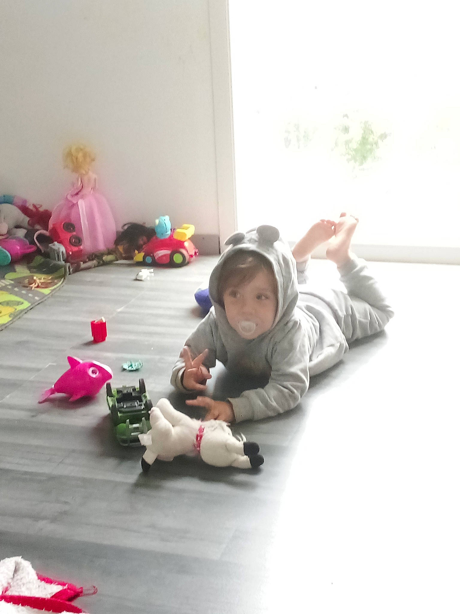 Guilio a rejoint le concours — aidez-le/la à gagner de superbes lots ! carmine, child, comfort, curtain, floor, flooring, foot, fun, grass, hardwood, human_leg, knee, leisure, person, play, room, sitting, sneakers, toddler, toy