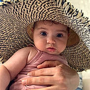 Elif participe au concours pour gagner de l'argent avec cette photo : baby, child, infant, hat, straw_hat, pink_tank_top, hand, holding, cute, curious, indoors, portrait, closeup, face, skin, eyebrows, eyelashes, fingernails, person, headwear