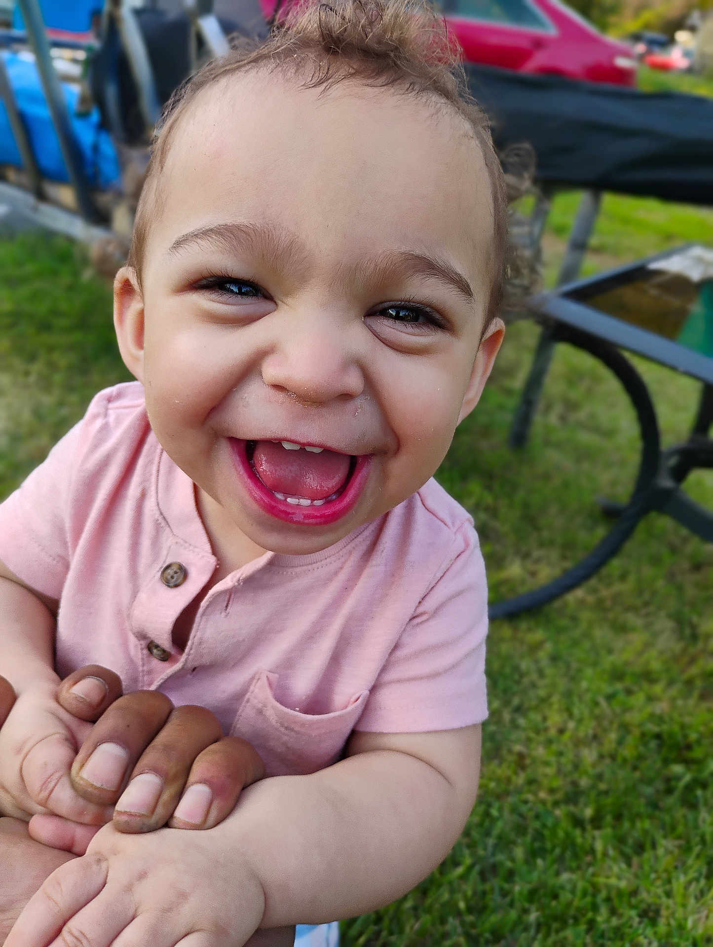 Corbin is registered to the contest to win money with this photo: toddler, child, smiling, happy, outdoor, grass, hands, person, face, shirt, pink_clothing, baby, daylight, portrait, closeup, curly_hair, fun, joy, nature, family