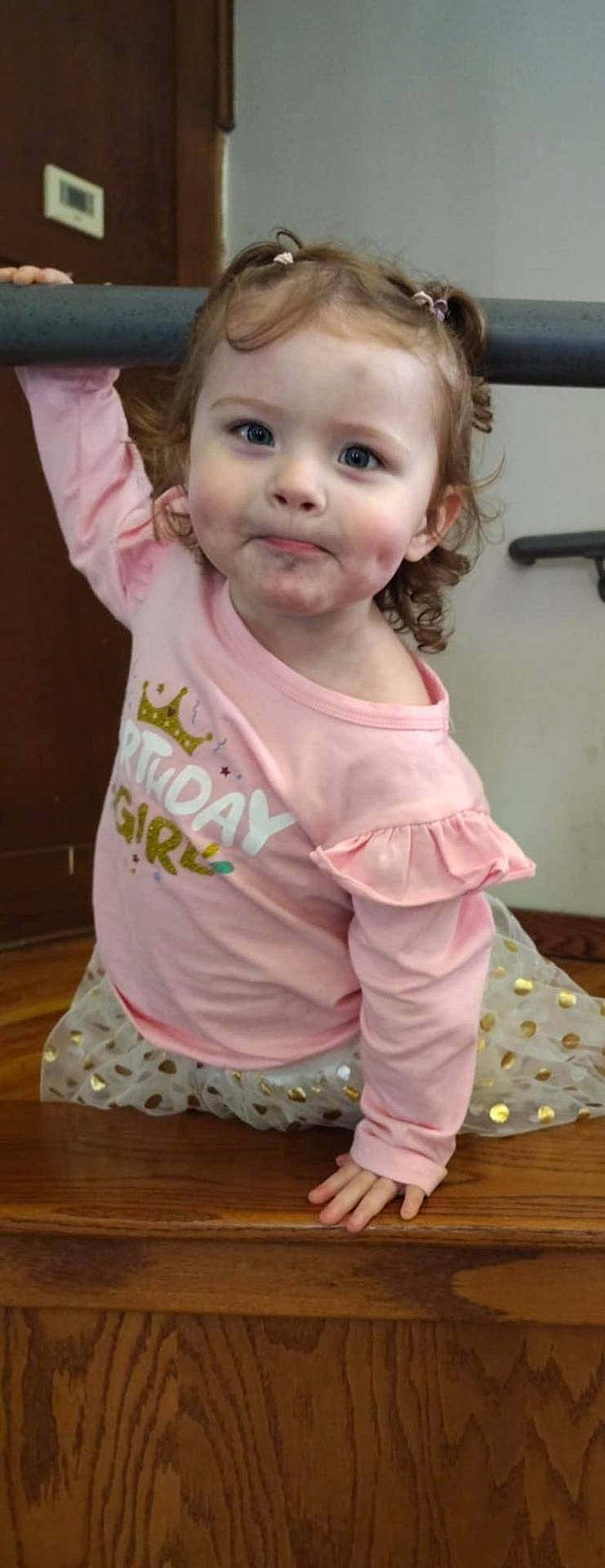 Oraya joined the competition — help win amazing prizes! birthday, child, clothing, curly_hair, cute, expression, face, girl, hand, indoor, person, pigtails, pink_shirt, playful, portrait, railing, skirt, smile, wooden_surface, young_child