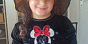Nallyah a rejoint le concours — aidez-le/la à gagner de superbes lots ! black_shirt, casual_clothing, child, curly_hair, cute, door, fashion, furniture, girl, happy, hat, home, indoor, long_hair, minnie_mouse, person, portrait, pumpkin_hat, smiling, wall