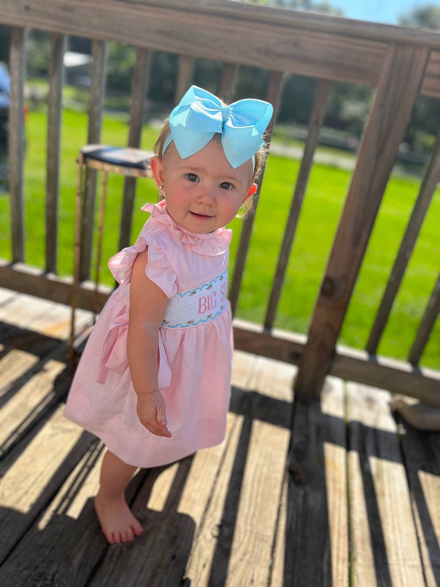 Haven is registered to the contest to win money with this photo: baby, baby_toddler_clothing, boardwalk, child, eyewear, fashion_accessory, fence, fun, grass, happy, hat, headwear, leisure, magenta, person, plant, recreation, sitting, smile, toddler