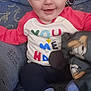 Vincent is registered to the contest to win money with this photo: baby, child, smile, face, blue_eyes, sitting, couch, striped_socks, colorful_shirt, toy, cartoon_character, happy, infant, indoor, clothing, cute, person, young_child, soft_toy, fabric