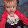 baby, blue_eyes, casual, child, clothing, colorful_shirt, couch, curious, cute, hand, home, indoor, infant, person, plush, portrait, sitting, soft_lighting, striped_socks, young_child