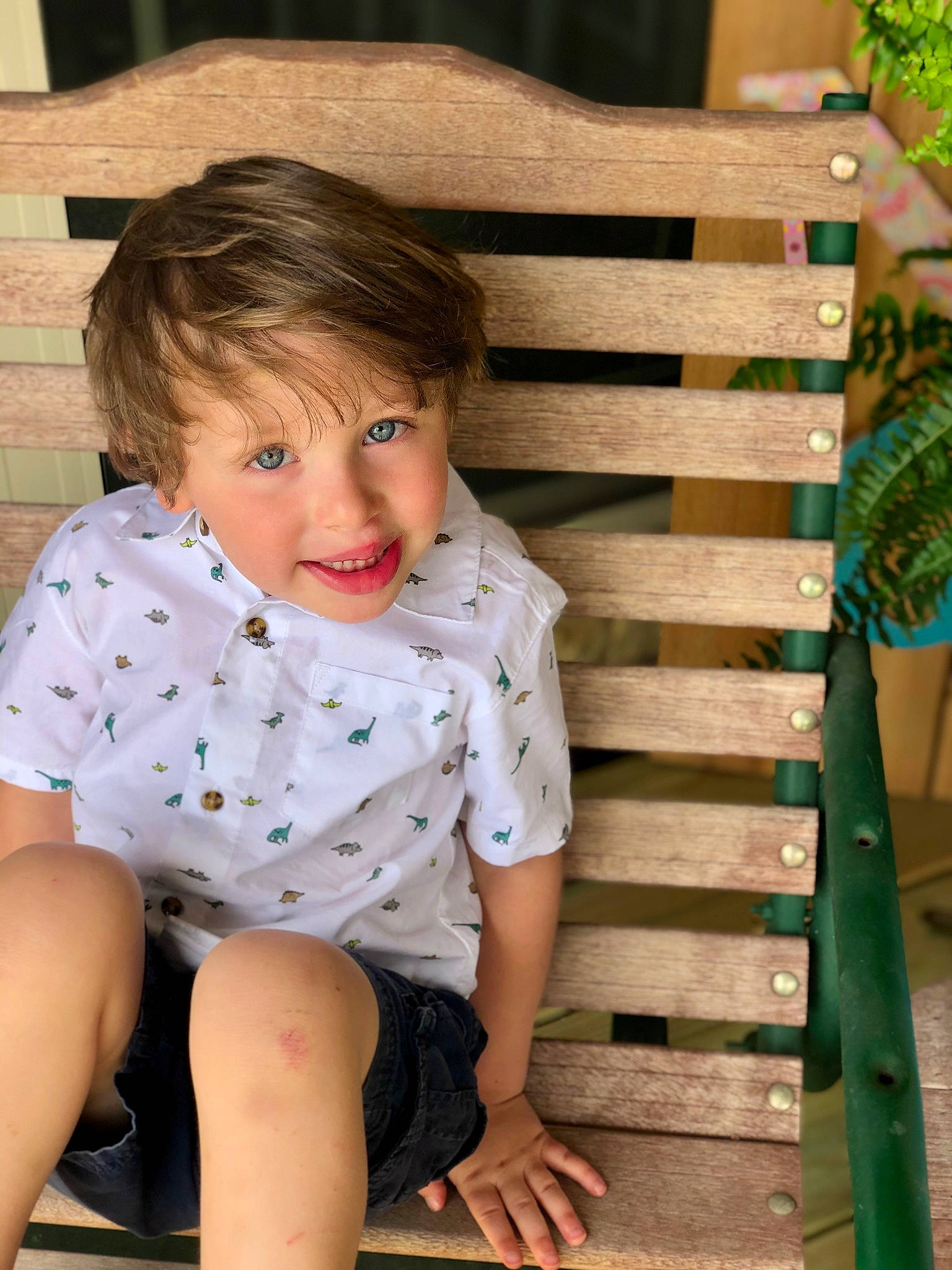 Jaxon is registered to the contest to win money with this photo: child, elbow, facial_expression, fashion, flash_photography, grass, hairstyle, happy, knee, leisure, mammal, outdoor_furniture, pattern, person, plant, shoulder, skin, sleeve, t_shirt, thigh