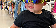 Liam joined the competition — help win amazing prizes! toddler, child, shopping_cart, sunglasses, black_shirt, clothing_store, retail, shopping, reflection, casual_wear, indoor, person, fashion, purple_pants, seatbelt, young_child, store_aisle, rack, apparel, modern