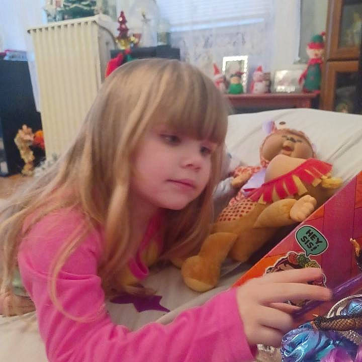 Paislee is registered to the contest to win money with this photo: arm, baby, bangs, chair, child, christmas_eve, doll, event, fun, hand, happy, holiday, lap, nail, person, play, reading, room, sharing, sitting