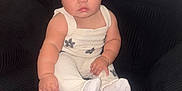 Hazel is registered to the contest to win money with this photo: baby, child, headband, bow, white_clothing, sitting, chair, black_chair, indoor, cute, portrait, infant, cute_expression, plush, cozy, small_bracelet, sock, curious, wide_eyes, pouting