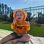 baby, blanket, casual_clothing, child, daylight, fence, grass, greenery, happy, nature, outdoor, playful, portrait, shorts, smiling, summer, sunglasses, sunhat, sunny, toddler