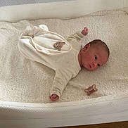 Abby a rejoint le concours — aidez-le/la à gagner de superbes lots ! baby, infant, bassinet, blanket, pacifier, sleepwear, soft, cozy, wooden_floor, face, newborn, laying, indoors, cute, child, person, resting, white, fabric, quiet