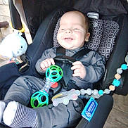 Lucas is registered to the contest to win money with this photo: baby, car_seat, child, child_safety, clothing, cute, fun, happy, holding, indoor, infant, joy, person, plaything, seat, seatbelt, smiling, socks, toy, young_child