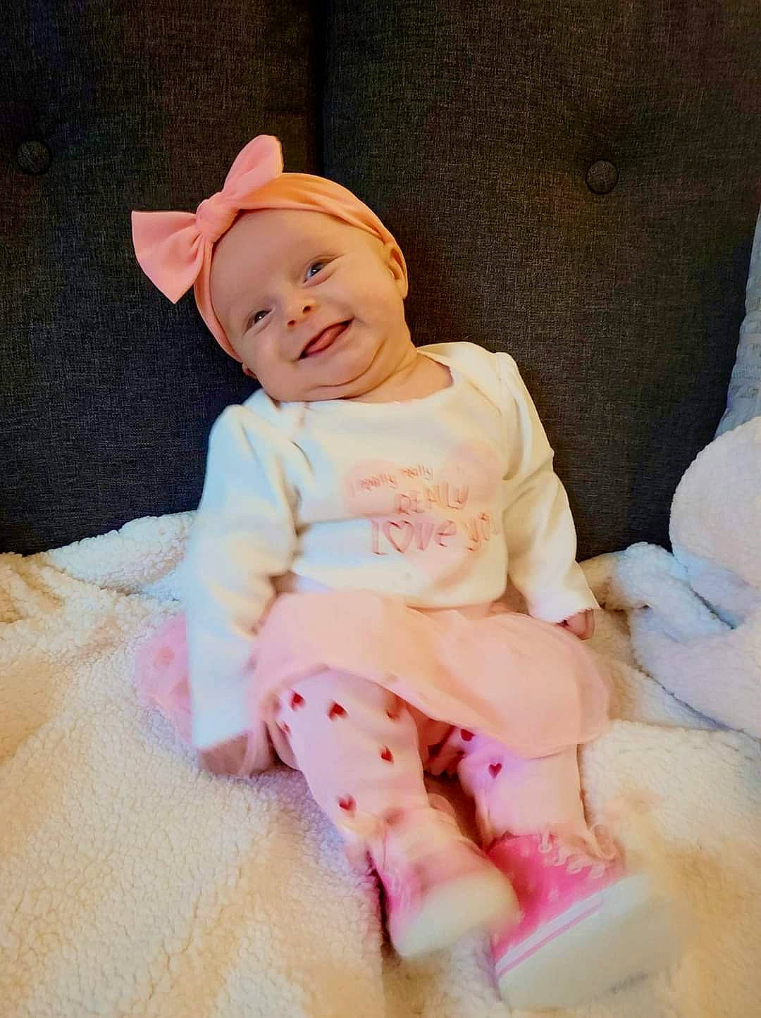 Harley is registered to the contest to win money with this photo: baby, baby_toddler_clothing, cheek, child, comfort, eye, fashion_accessory, happy, headwear, joy, knee, leg, magenta, pattern, peach, person, pink, skin, sleeve, smile