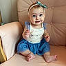 baby, child, blue_eyes, headband, bow, smile, armchair, clothing, dress, cute, infant, sitting, indoors, person, portrait, skin, foot, hand, happy, young