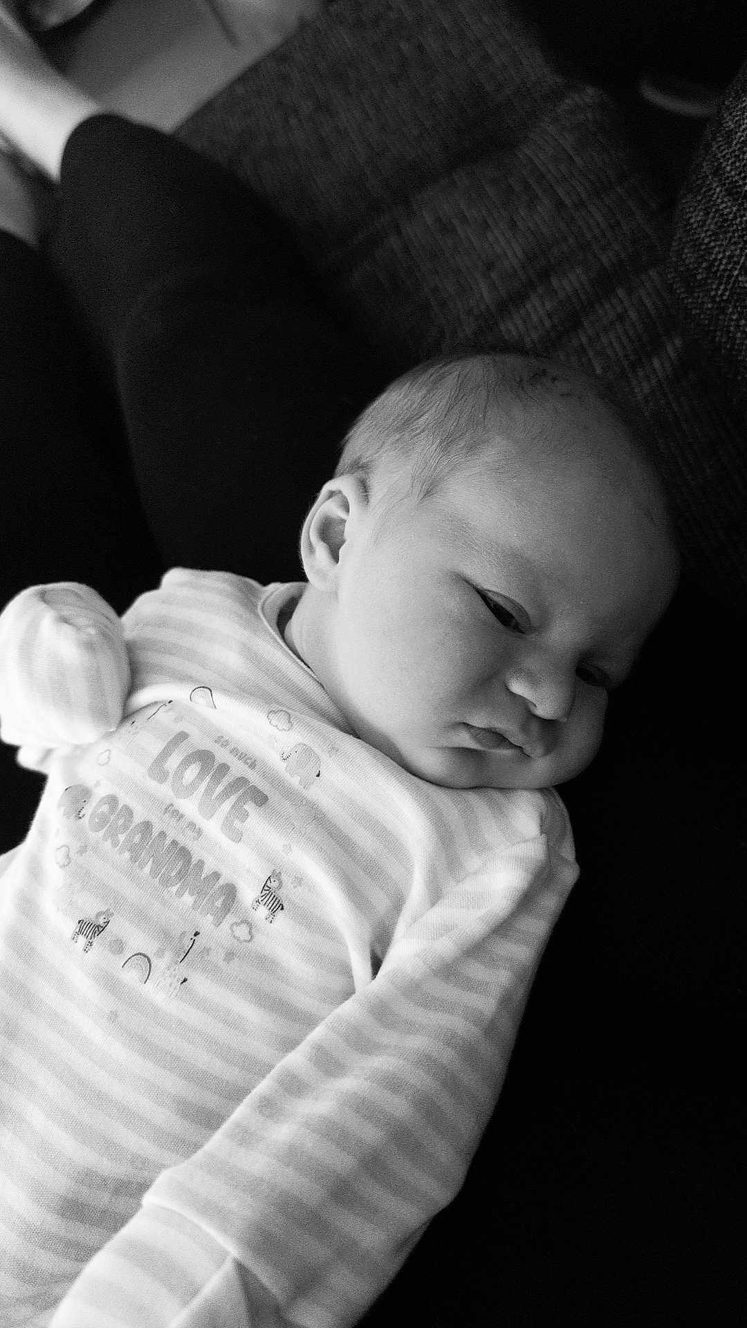 Liam-James joined the competition — help win amazing prizes! baby, infant, sleepy, striped_clothing, pajamas, person, face, head, ear, hand, lap, couch, black_and_white, monochrome, relaxing, comfort, closeup, portrait, newborn, soft